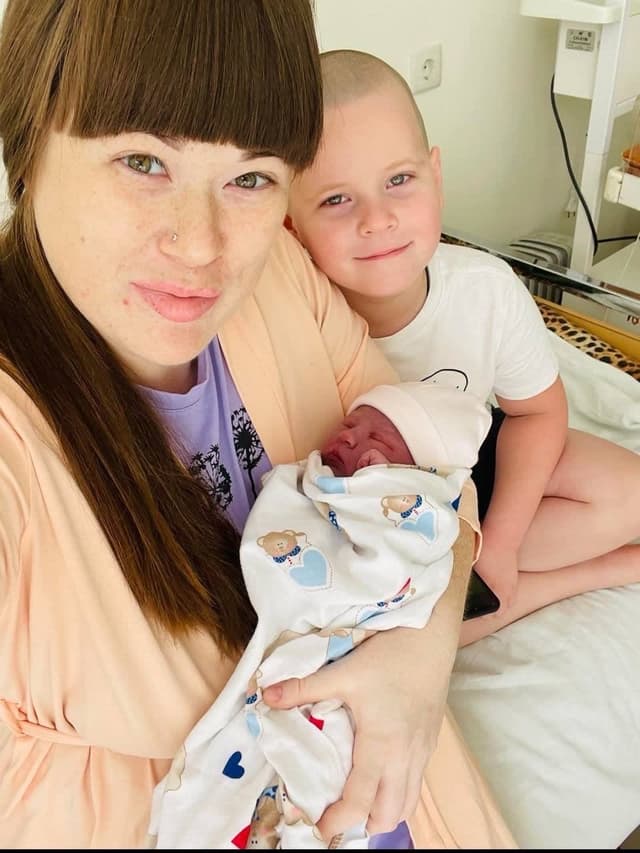 A woman holding a baby in a hospital bed