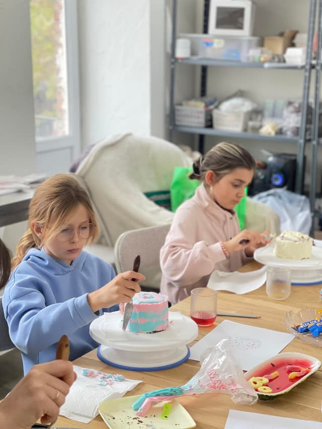 A group of children sitting around a table eating cake