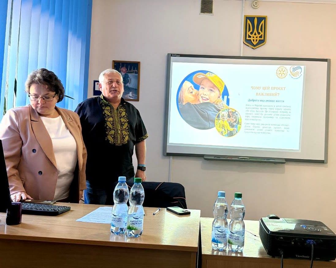 A man and a woman standing in front of a computer
