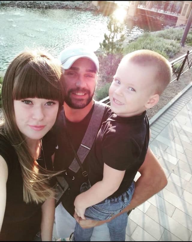 A man, woman and child posing for a picture