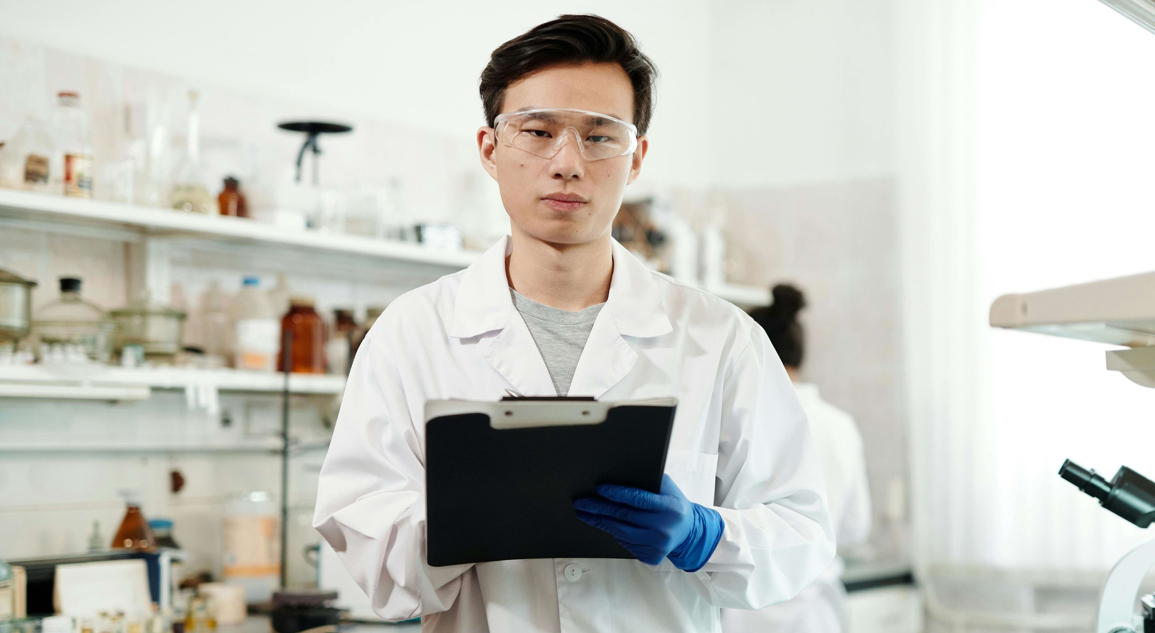 A man in a lab coat holding a tablet