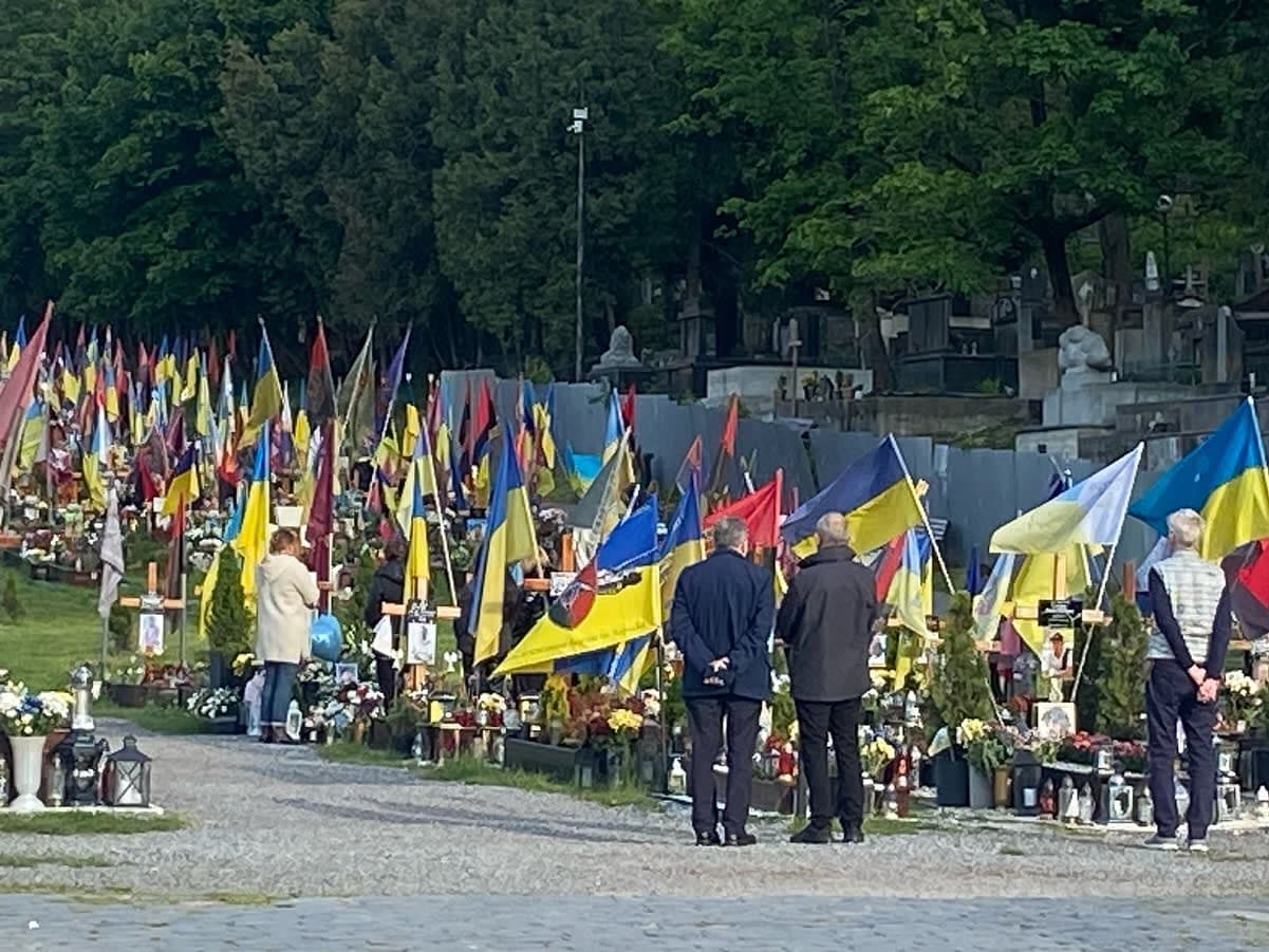 A group of people standing next to each other near flags
