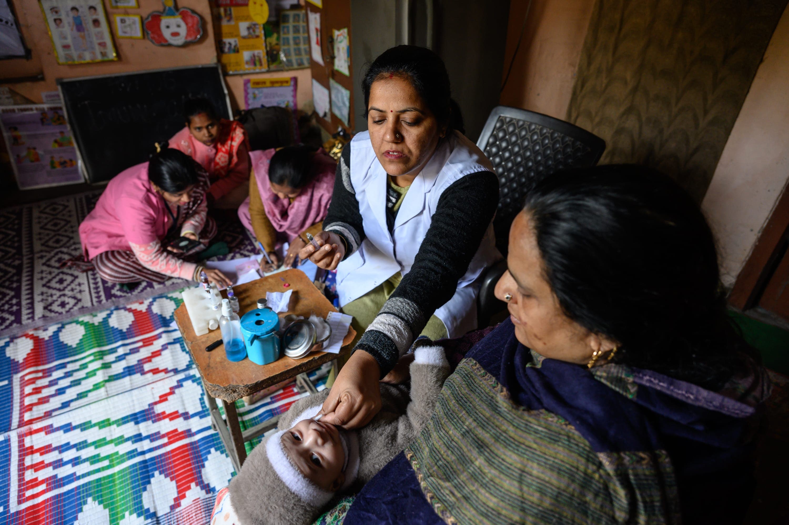 A group of women sitting around a baby