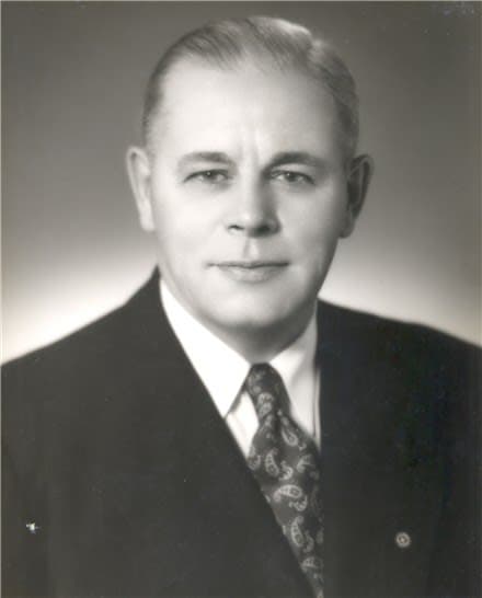 A black and white photo of a man in a suit and tie