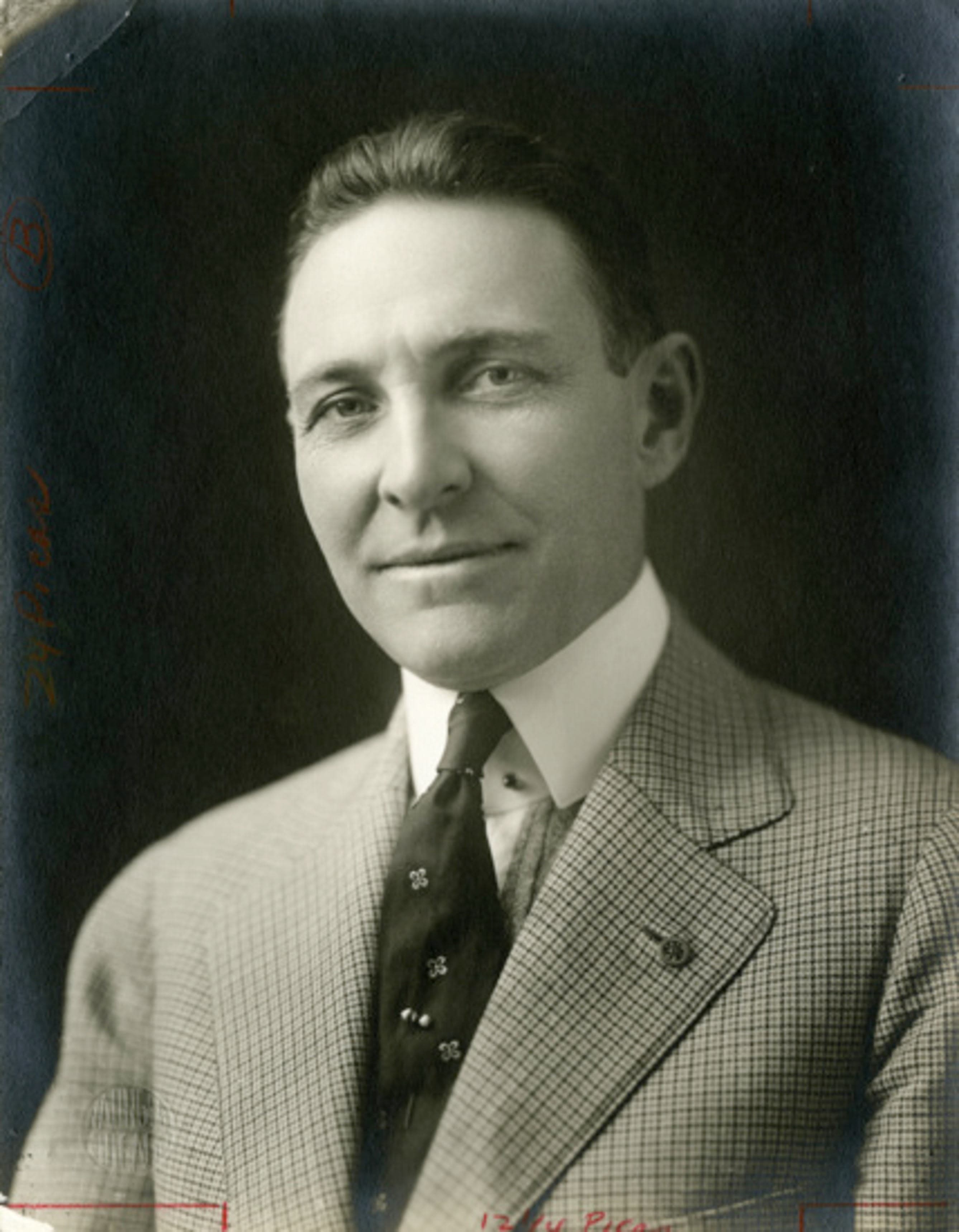 A black and white photo of a man in a suit and tie