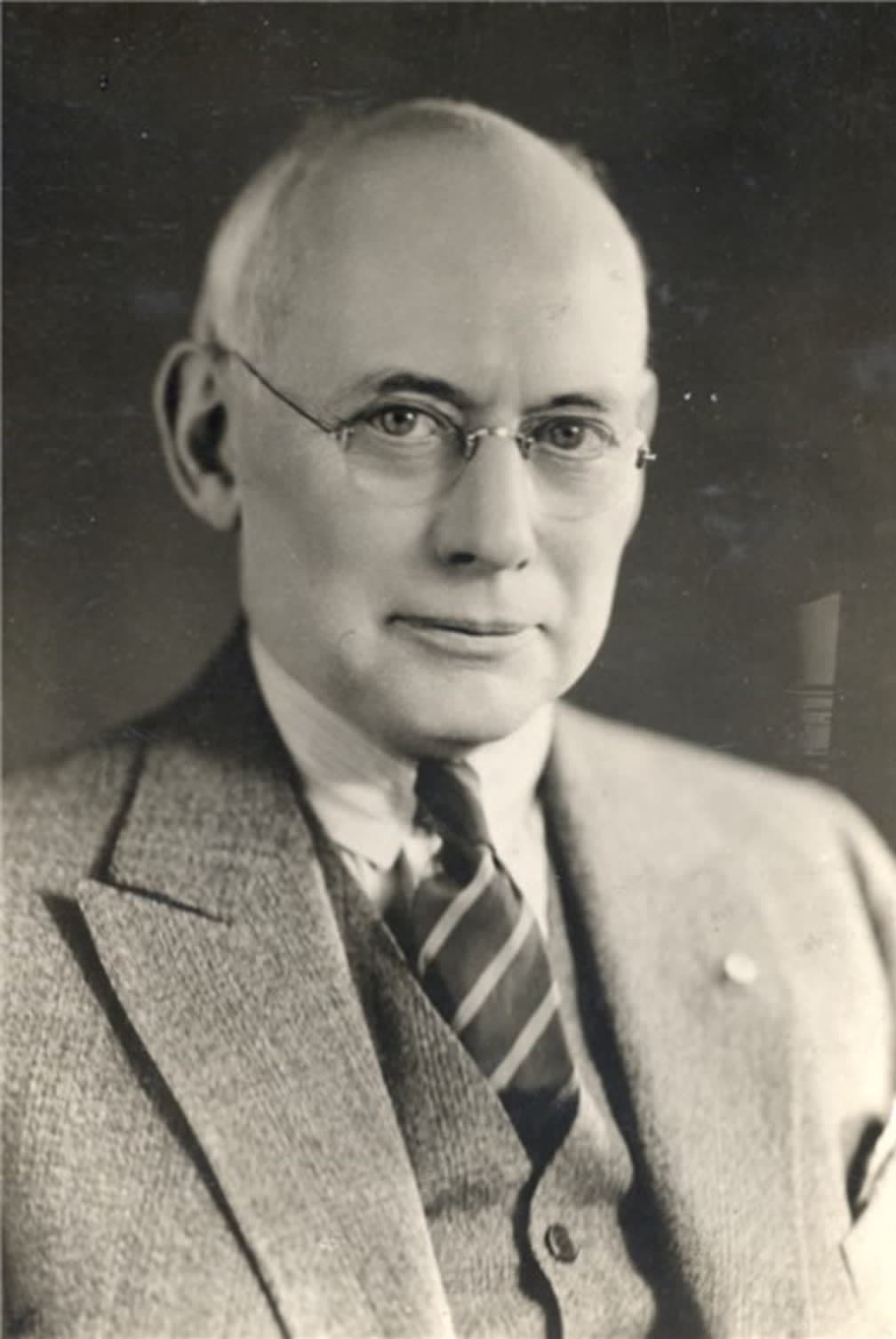 A black and white photo of a man in a suit and tie