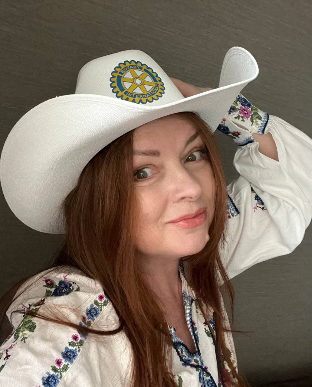 A woman wearing a white cowboy hat and a white shirt