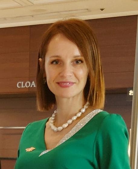 A woman in a green dress standing in front of a door