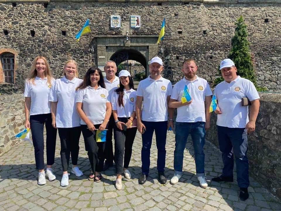 A group of people standing in front of a stone building