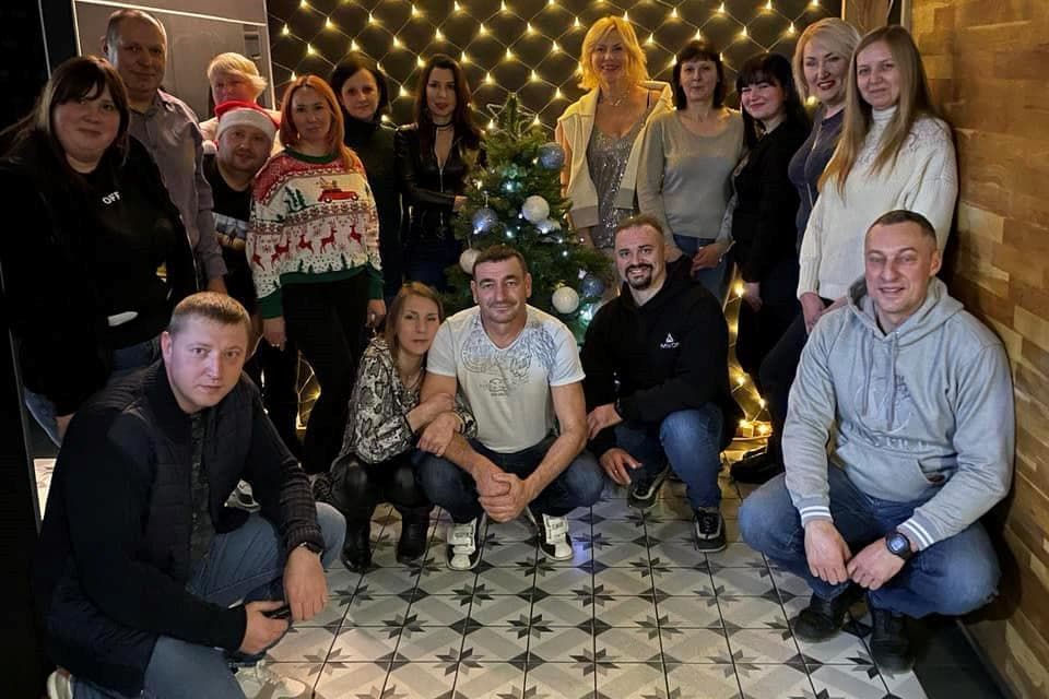 A group of people posing for a picture in front of a christmas tree