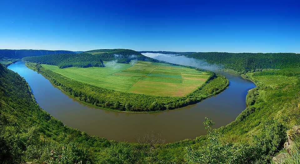 A river running through a lush green countryside