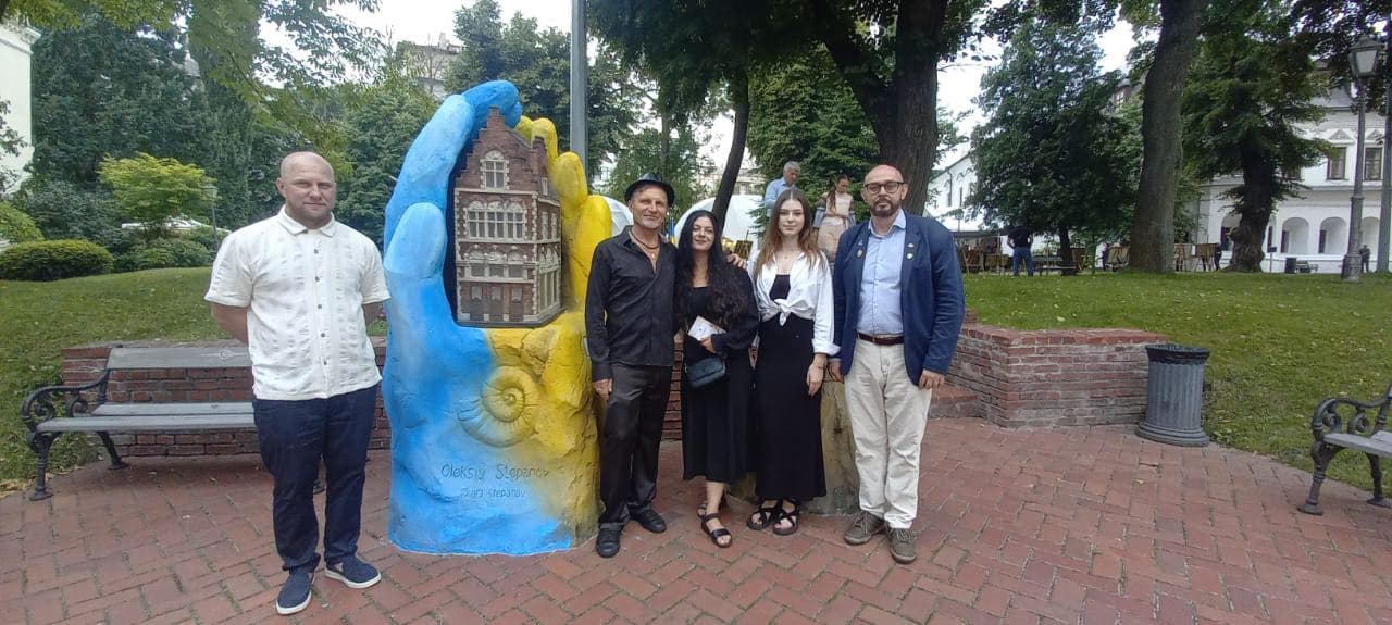 A group of people standing in front of a statue