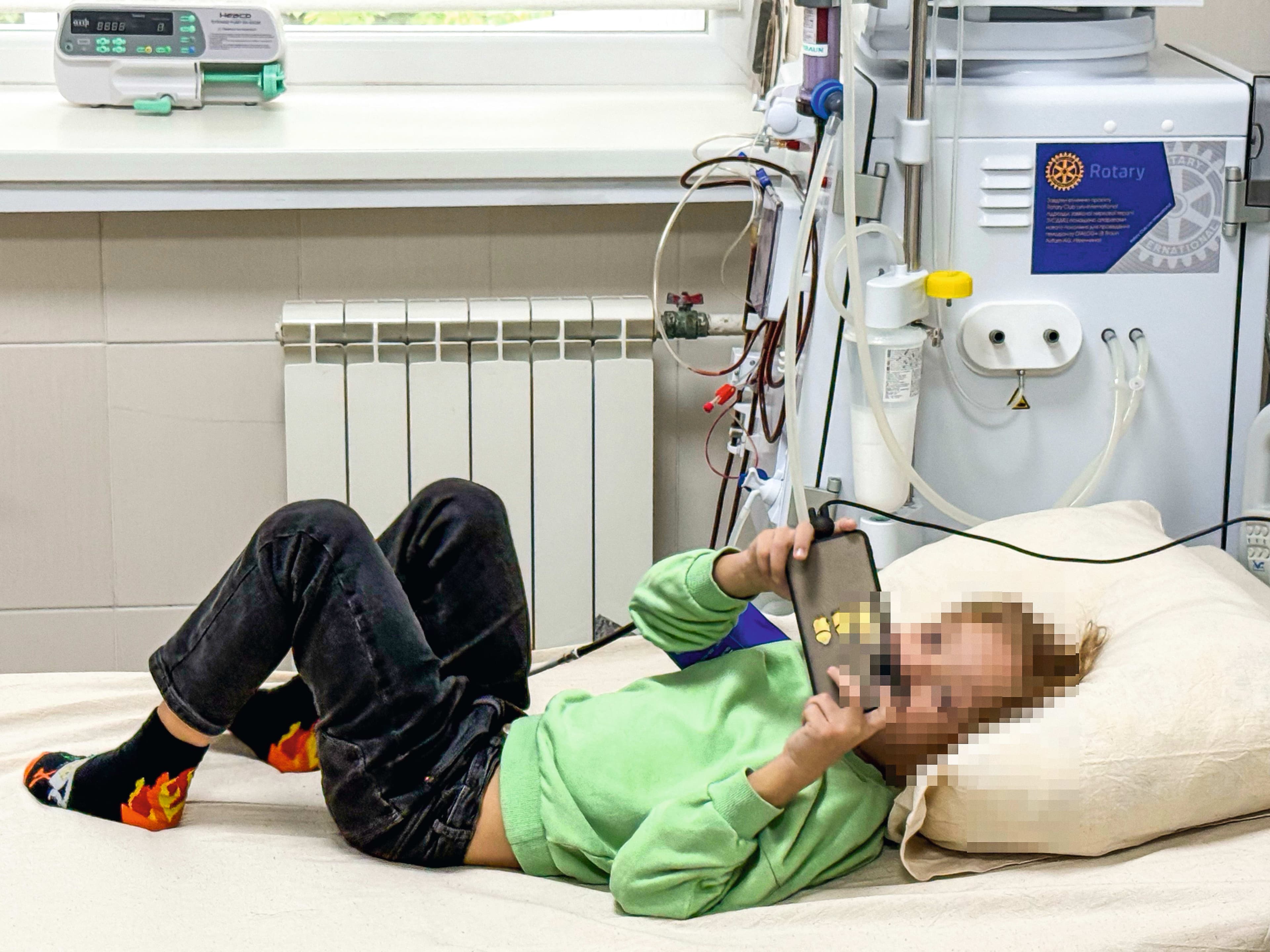A young boy laying on a pillow in a hospital