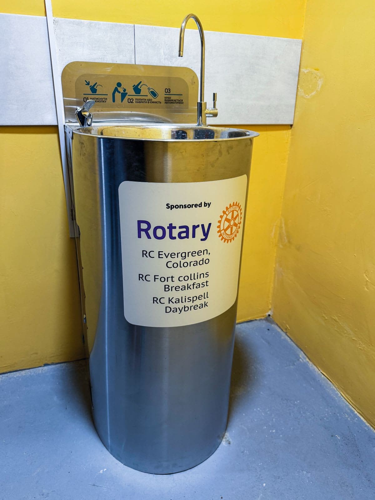 A metal trash can with a sign on it