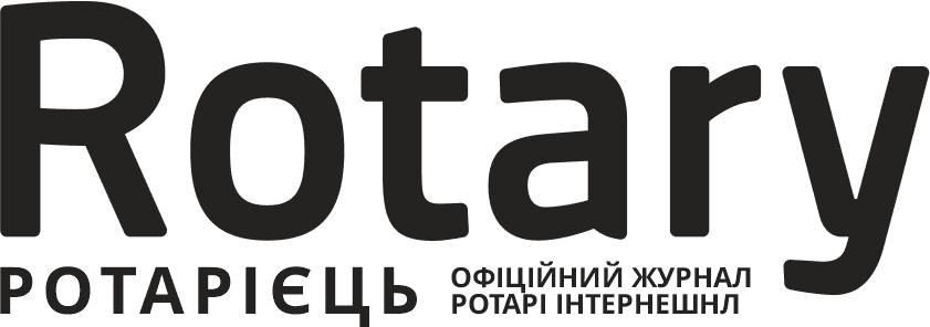 A black and white photo of the rotary logo