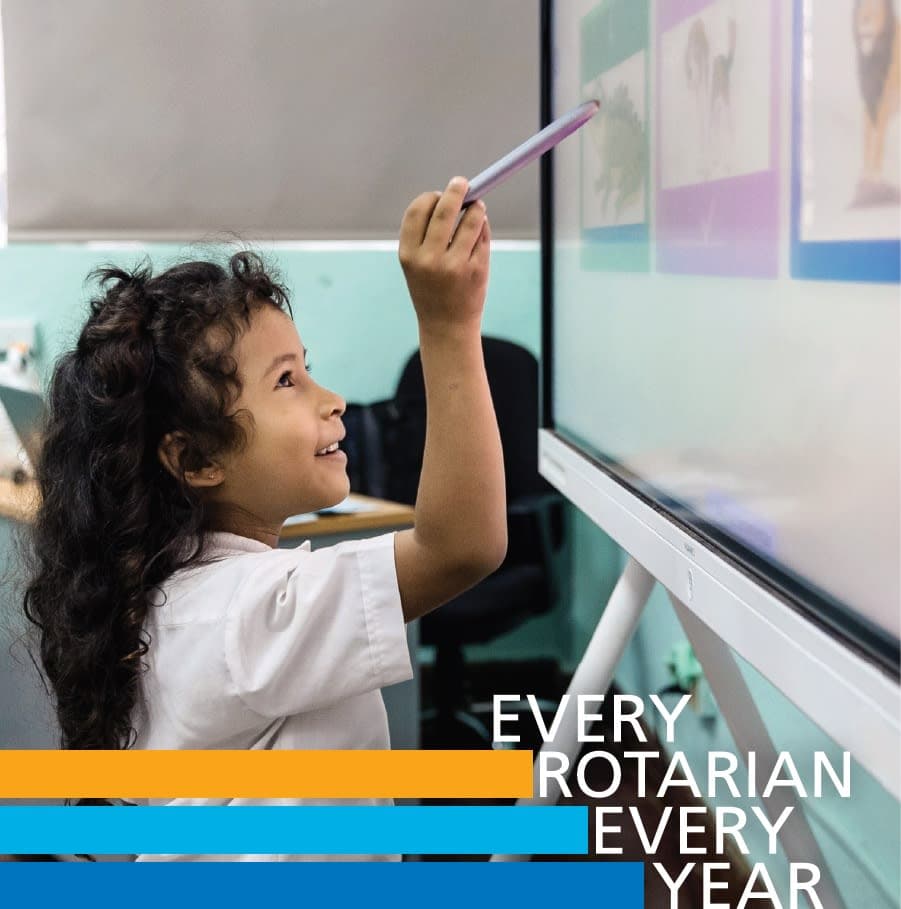 A young girl writing on a white board