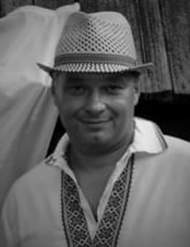 A black and white photo of a man wearing a hat