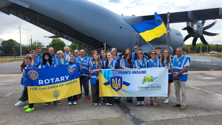 A group of people standing in front of an airplane