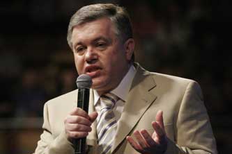 A man in a suit speaking into a microphone