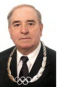 A man in a suit and tie with a necklace on his neck