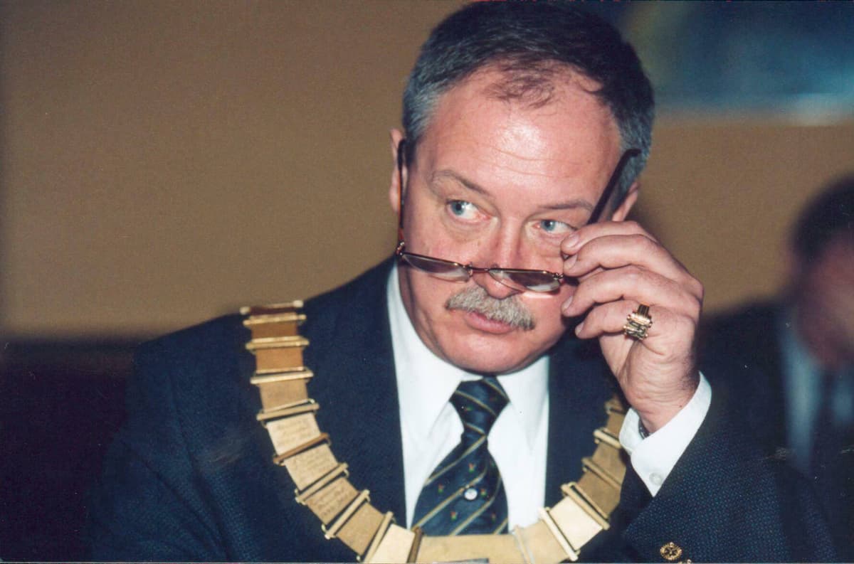 A man in a suit and tie talking on a cell phone
