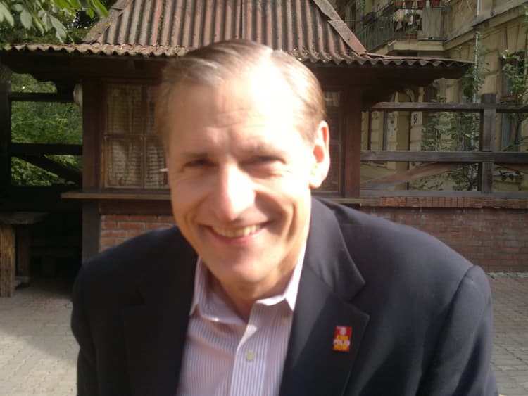 A man in a suit smiling for the camera