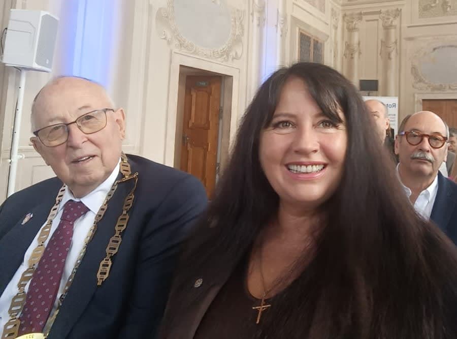 A woman standing next to a man in a suit