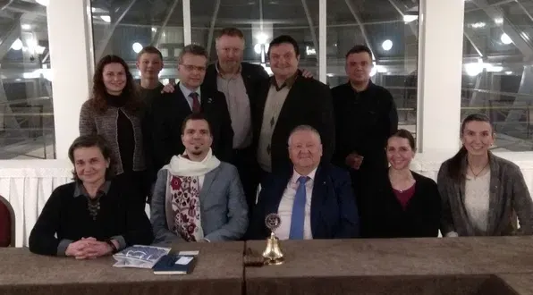 A group of people posing for a picture in front of a table
