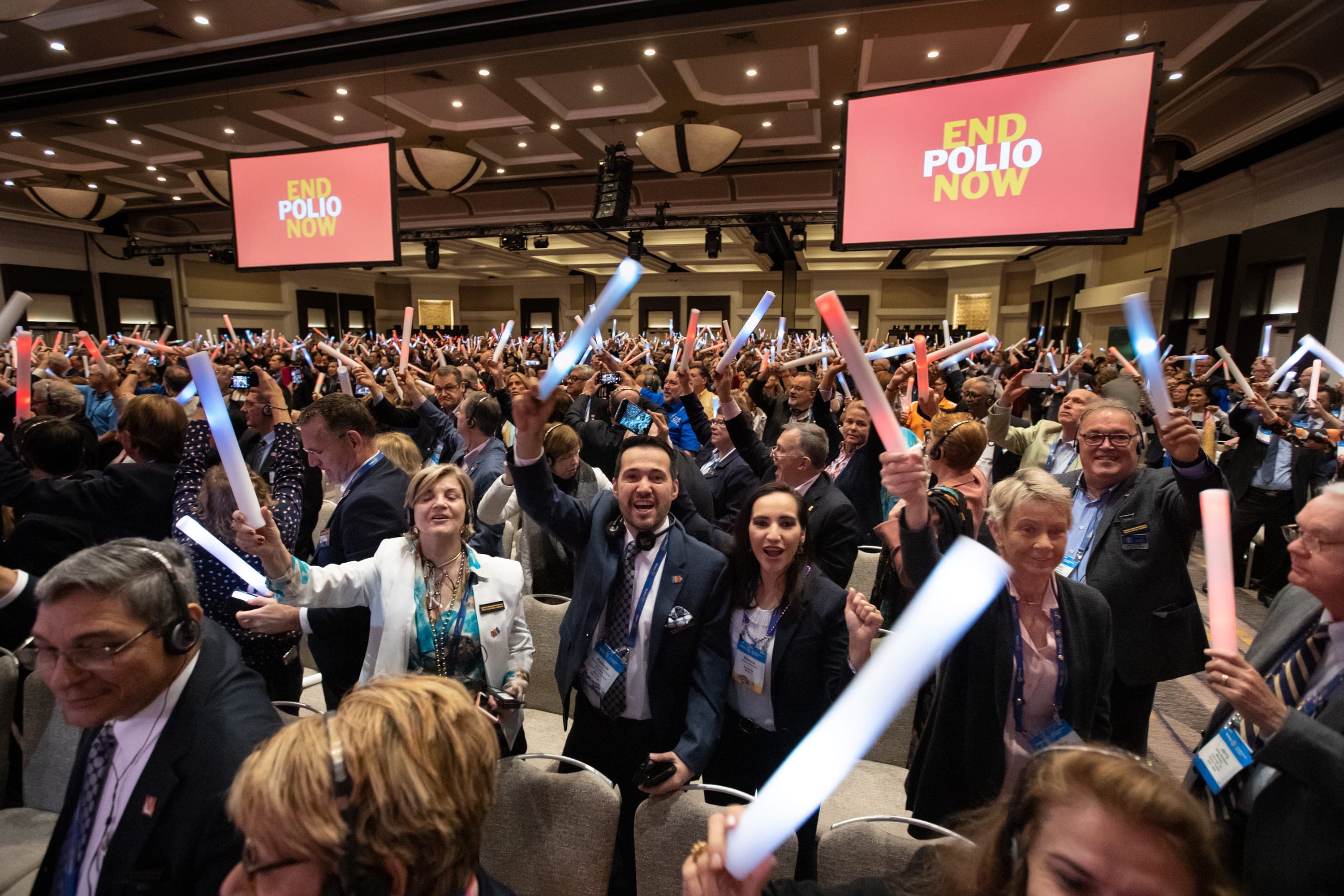 A large group of people holding up a pair of toothbrushes