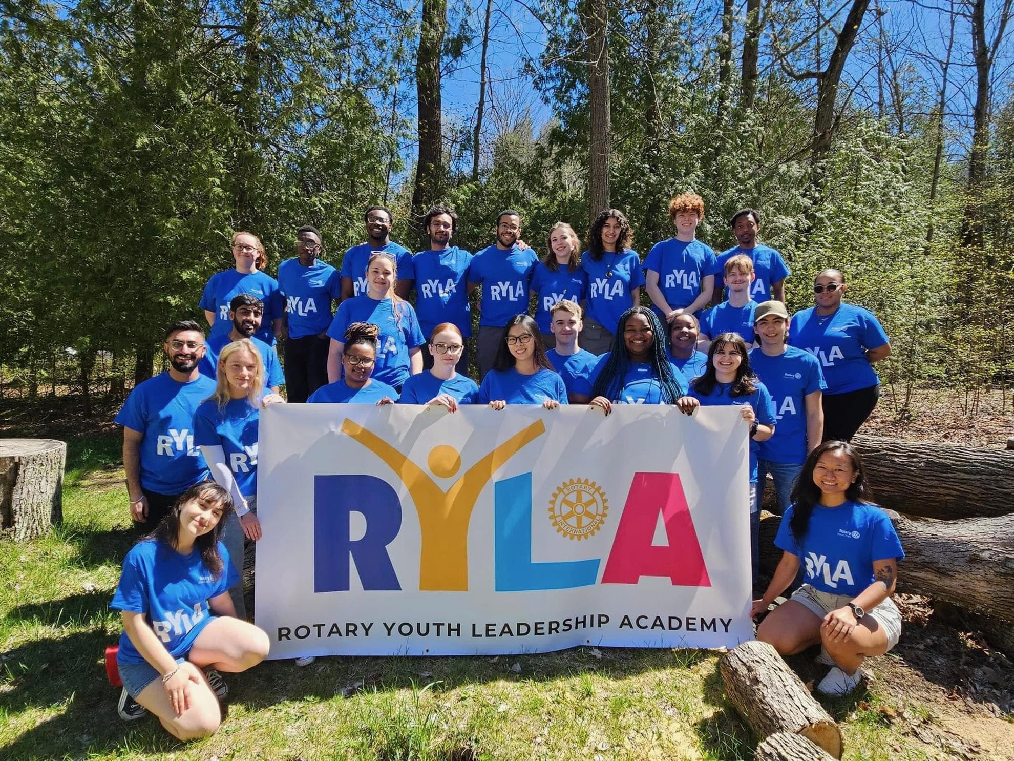 A group of people in blue shirts holding a banner