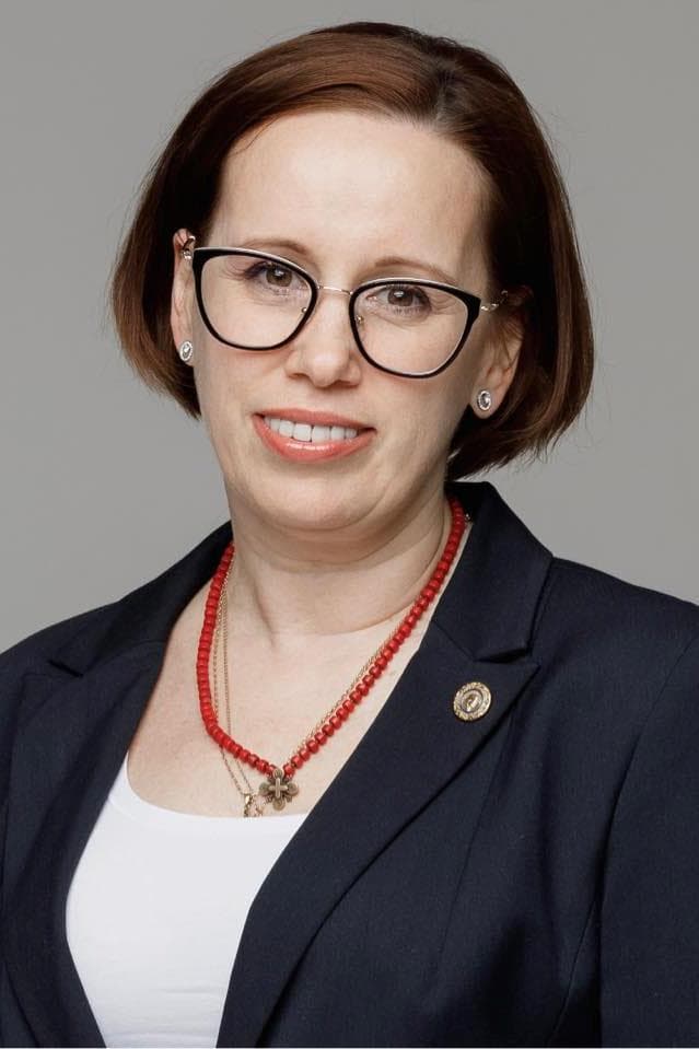 A woman wearing glasses and a necklace