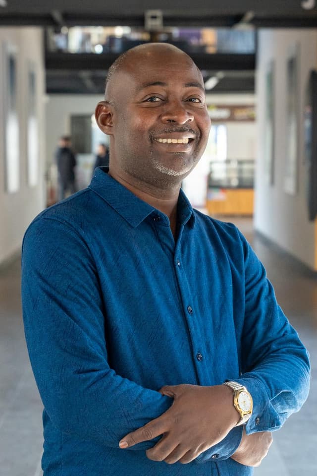 A man in a blue shirt is smiling