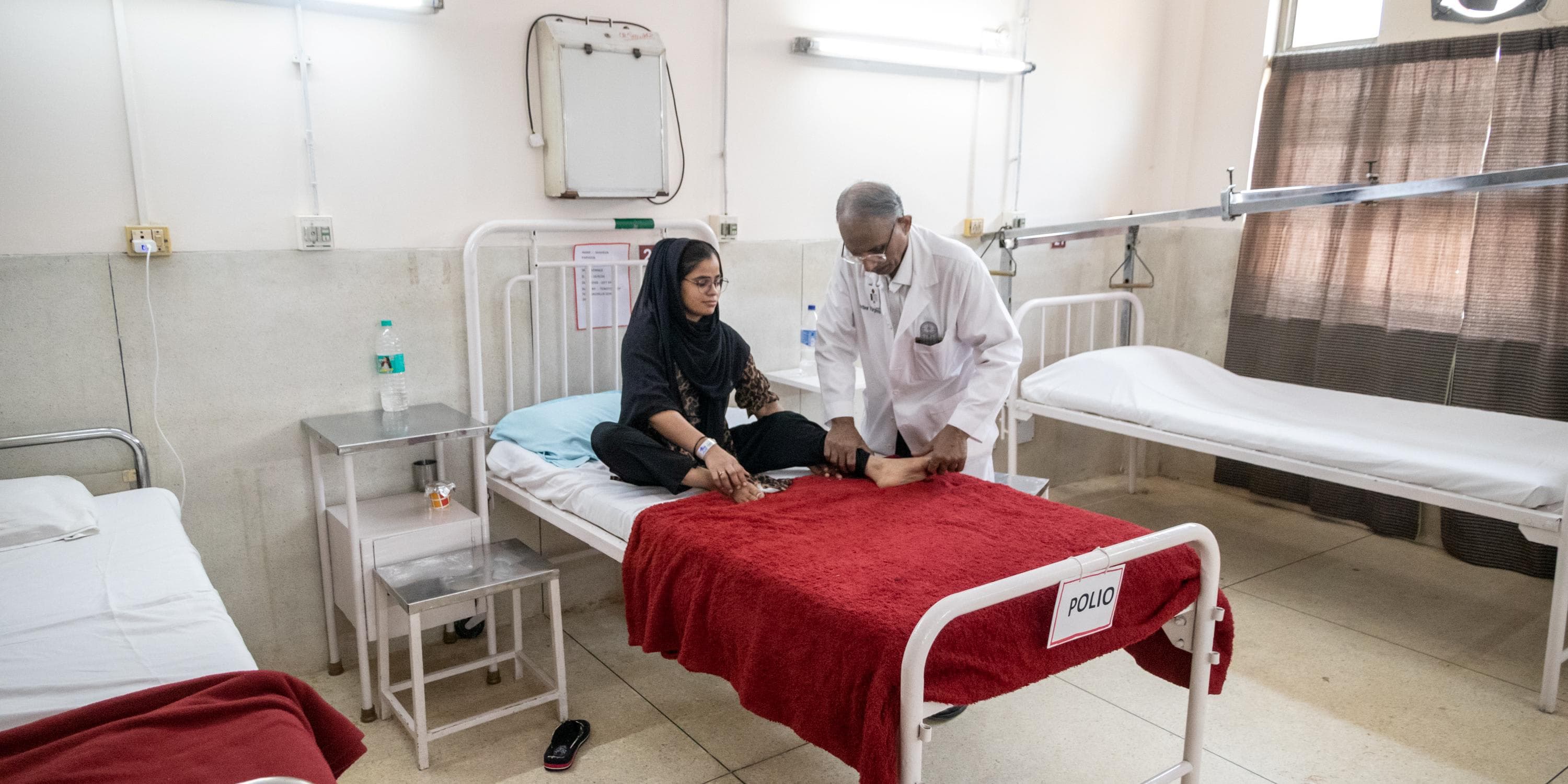 A man and a woman sitting on a hospital bed