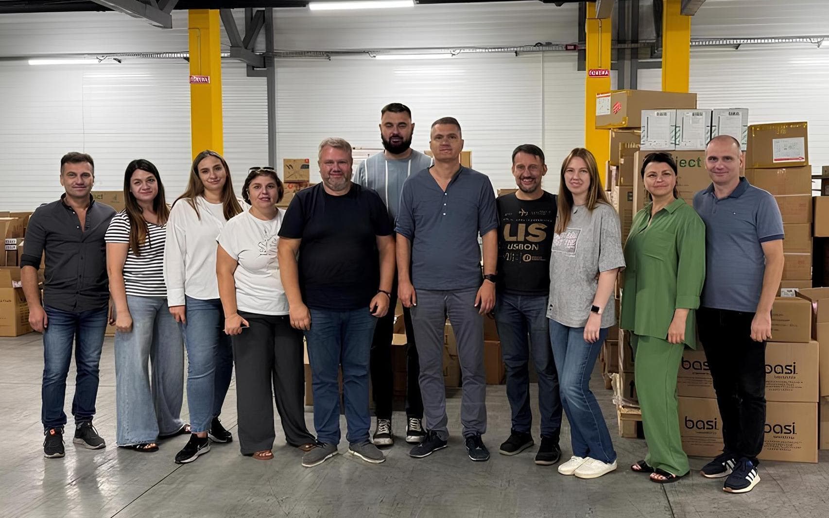 A group of people standing next to each other in a warehouse