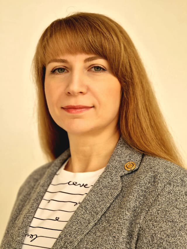 A woman with long red hair wearing a jacket