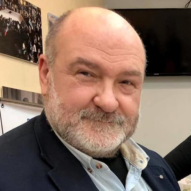 A close up of a person wearing a suit and tie